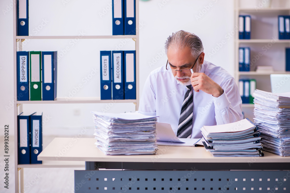 Fototapeta premium Old male employee unhappy with excessive work in the office