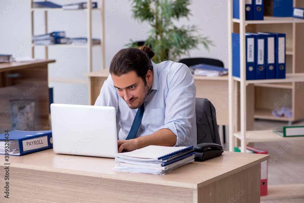 Young male bookkeeper working in the office Young male bookkeeper working in the office