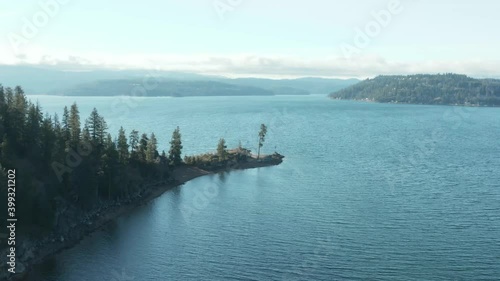 Panning around Tubbs Hill tree on Coeur d'Alene lake in scenic aerial shot photo