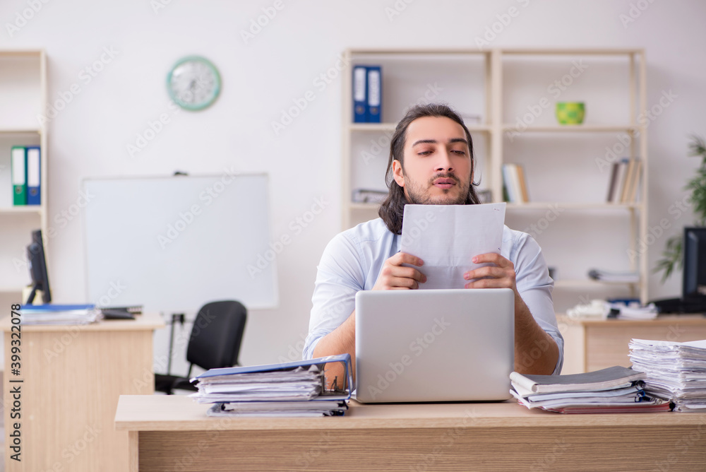 Young male employee unhappy with excessive work Young male employee unhappy with excessive work