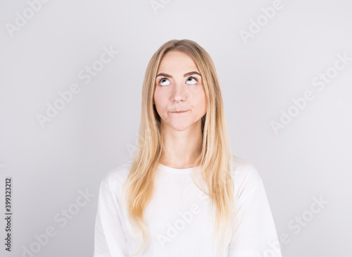 Photo of amazing blonde girl looking up empty space deep thinking isolated on grey background © MP Studio