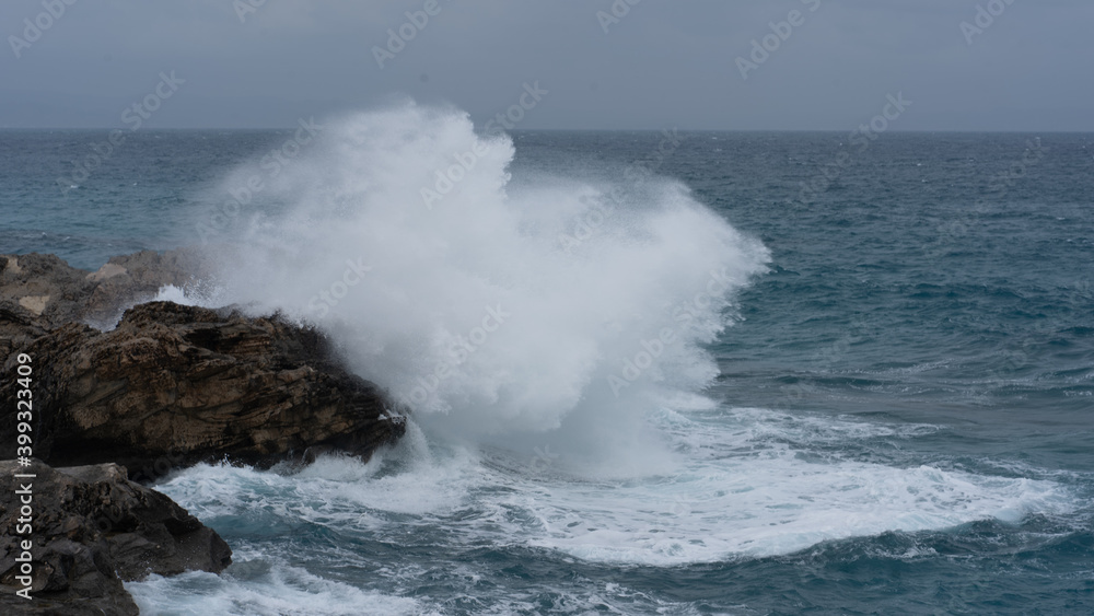 waves crashing against the rocks on a windy day waves crashing against the rocks on a windy day