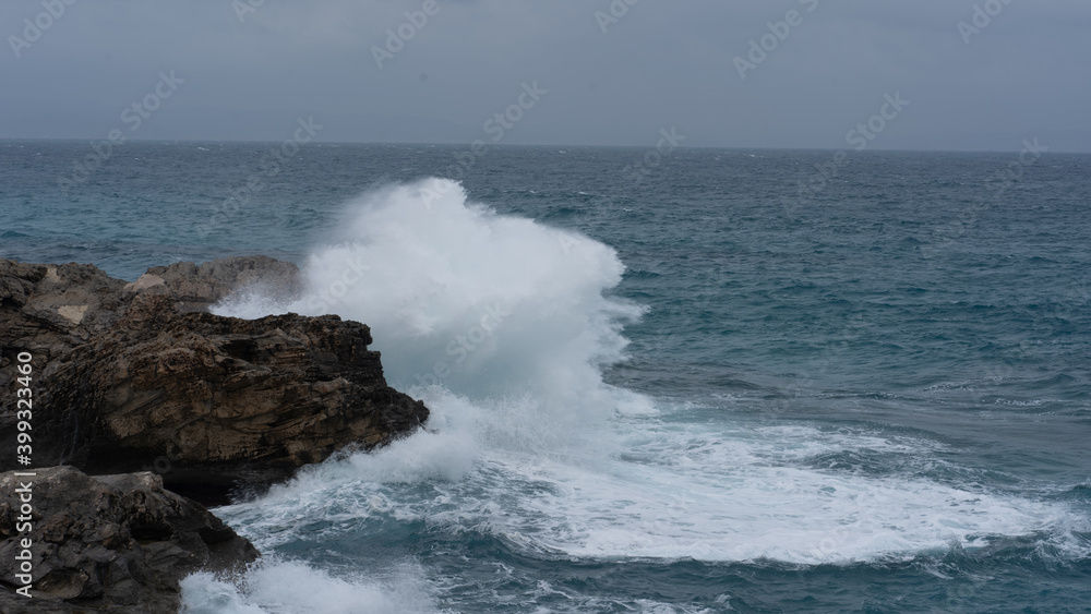 waves crashing against the rocks on a windy day waves crashing against the rocks on a windy day