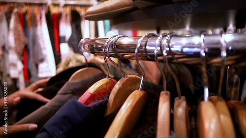 African American black woman wearing a mask is shopping around for clothes in a local thrift store find the perfect fashion style of the up coming season. 