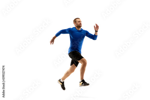 Power. Caucasian professional jogger, runner training isolated on white studio background. Muscular, sportive man, emotional. Concept of action, motion, youth, healthy lifestyle. Copyspace for ad.