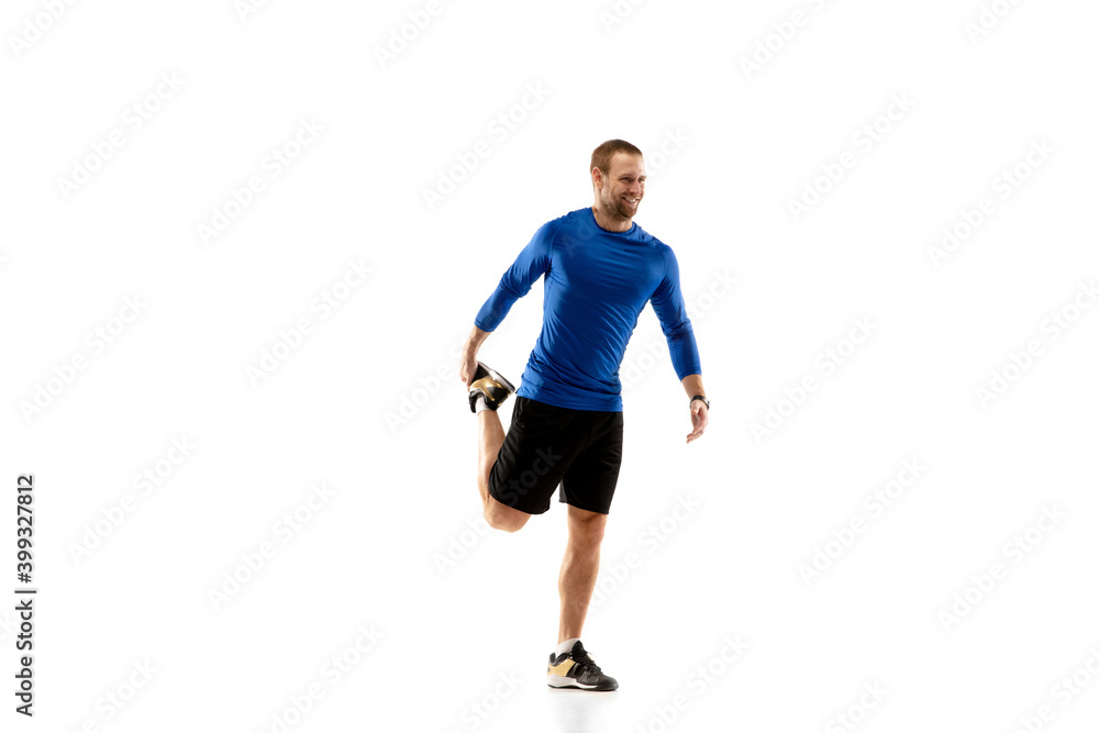 Prepares. Caucasian professional jogger, runner training isolated on white studio background. Muscular, sportive man, emotional. Concept of action, motion, youth, healthy lifestyle. Copyspace for ad.