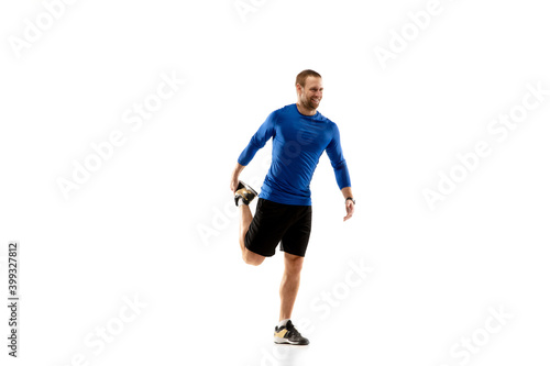 Prepares. Caucasian professional jogger  runner training isolated on white studio background. Muscular  sportive man  emotional. Concept of action  motion  youth  healthy lifestyle. Copyspace for ad.