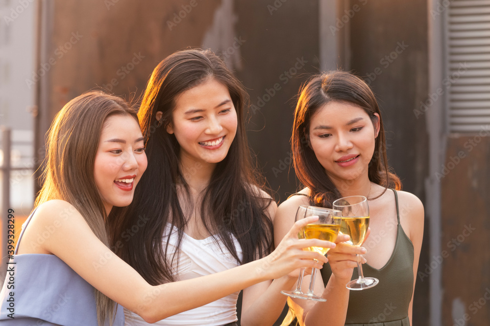 asian woman teenagers cheering and toast with white sparkling wine glass to celebrating at dinner party in summertime. celebration, relationship and friendship concept. asian woman teenagers cheering and toast with white sparkling wine glass to celebrating at dinner party in summertime. celebration, relationship and friendship concept.