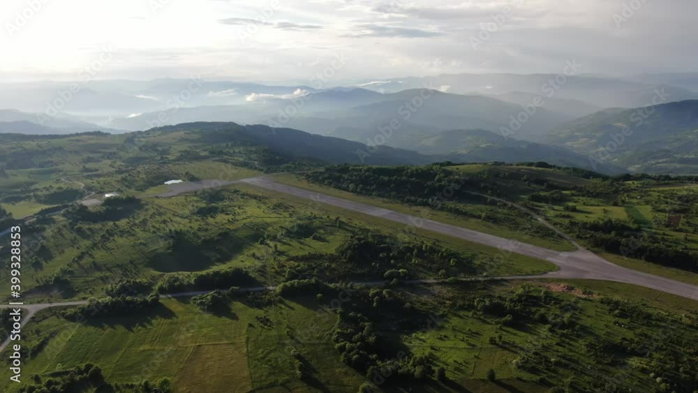 Aerial View of Ponikve Airport Near Uzice City, Serbia on Sunny Summer Evening. Remaining Holes of NATO Bombing by Runway, Drone Shot Aerial View of Ponikve Airport Near Uzice City, Serbia on Sunny Summer Evening. Remaining Holes of NATO Bombing by Runway, Drone Shot