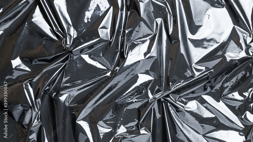 Smooth texture. Black shiny film bag pattern. Wrap transparent dark cellophane background. Real texture of polyethylene foil. Smooth texture. Black shiny film bag pattern. Wrap transparent dark cellophane background. Real texture of polyethylene foil.