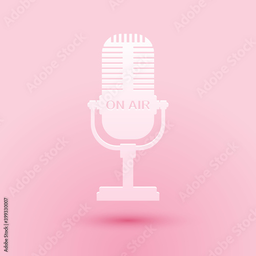 Paper cut Microphone icon isolated on pink background. On air radio mic microphone. Speaker sign. Paper art style. Vector.