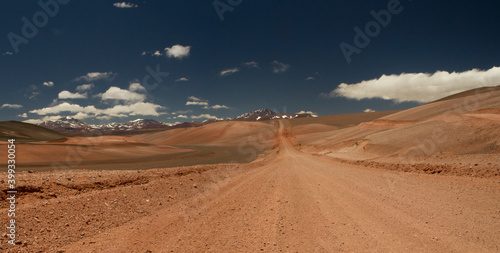 The dirt road high in the Andes mountains. Traveling along the route across the arid desert and mountain range. The sand and death valley under a deep blue sky in La Rioja, Argentina. 