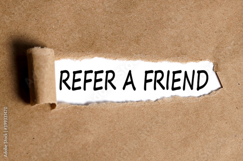 REFER A FRIEND text on white paper with torn paper background