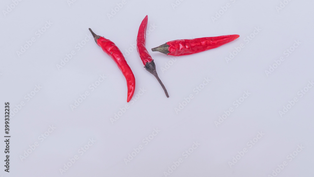 Close-up view of red hot chili peppers on white background. Spicy cuisine concept. Close-up view of red hot chili peppers on white background. Spicy cuisine concept.