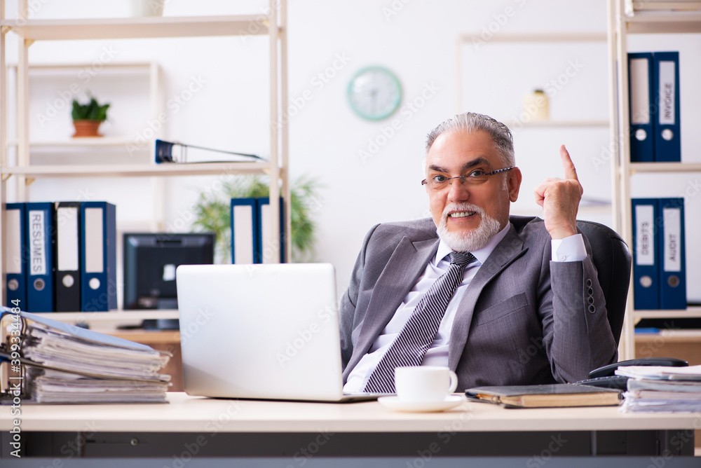 Old male employee working in the office Old male employee working in the office
