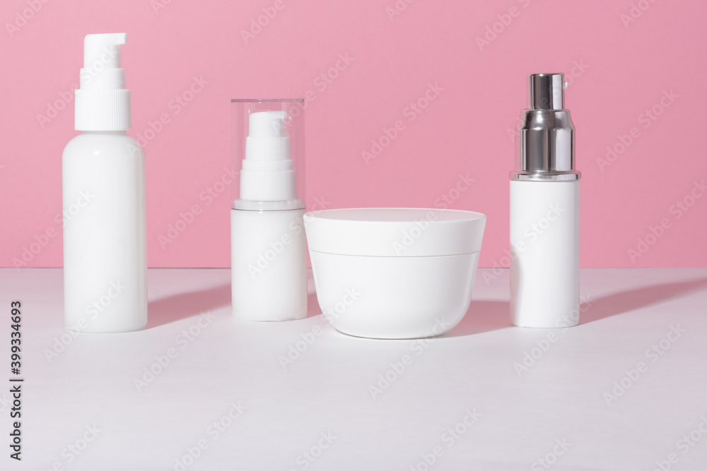 Set of white cosmetic bottles and jars with hard shadows. Beauty salon concept. Set of white cosmetic bottles and jars with hard shadows. Beauty salon concept.