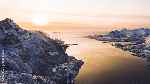 Breathtaking bird's eye view of majestic fjord mountains covered with snow in winter. Aerial view of scenery rock peaks, picturesque beautiful nature landscape. Lofoten Island surrounds by Nordic sea