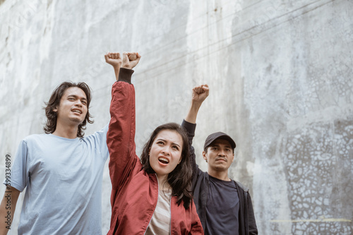 Portrait students who are burning with enthusiasm doing a demonstration together photo