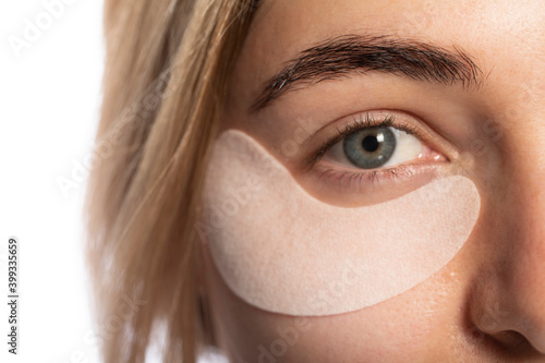 Eye patch on the face of a young woman on a light background.