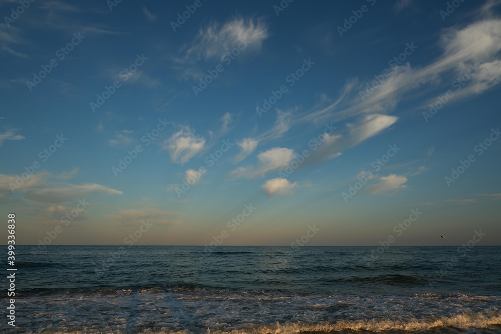 Sea beach with blue sky and yellow sand and some clouds