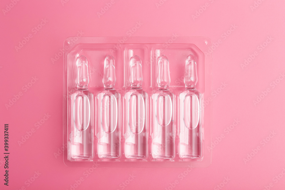 Medical ampoules with a vaccine on a pink background. Medicine for disease or medicine for health concept. Medical ampoules with a vaccine on a pink background. Medicine for disease or medicine for health concept.