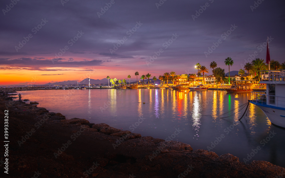 A view from the Ancient City Harbor of Side, long exposure and colored lights at sunset in Antalya Turkey