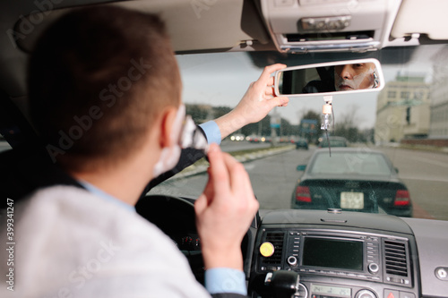 Photography Businessman shaving in car by razor and foam at the wheel