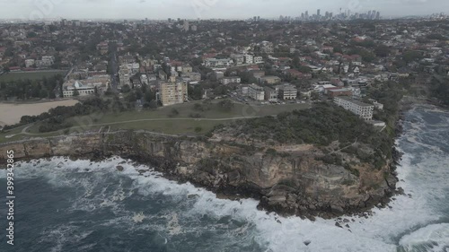 Coogee City With Gordons Bay Beach On A Stormy Day - Dangerous Waves Crashing On Cliffs - Sydney, NSW, Australia. - aerial sideways photo