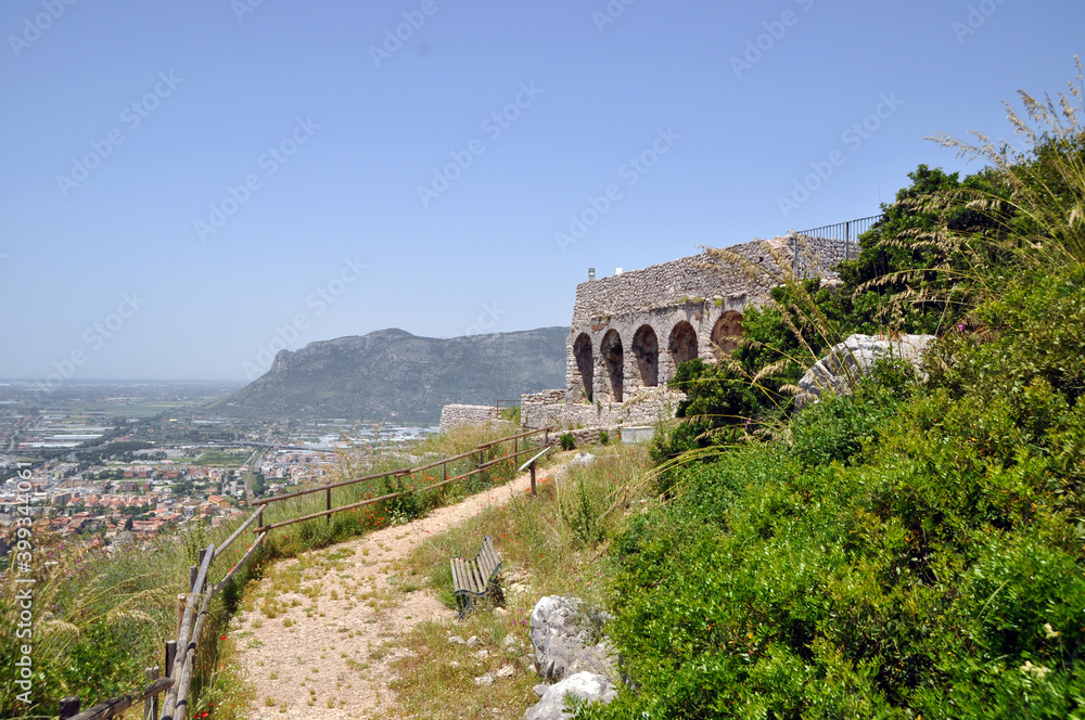 Ruins of an old stone building. Wooden fence along the path.