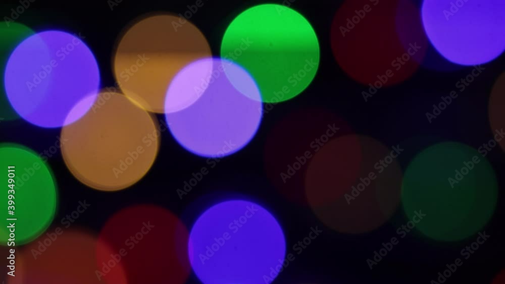 Christmas blur background. Shimmering colored circles defocused christmas lights video. Multicolored light leaks 4k footage on dark background Christmas blur background. Shimmering colored circles defocused christmas lights video. Multicolored light leaks 4k footage on dark background