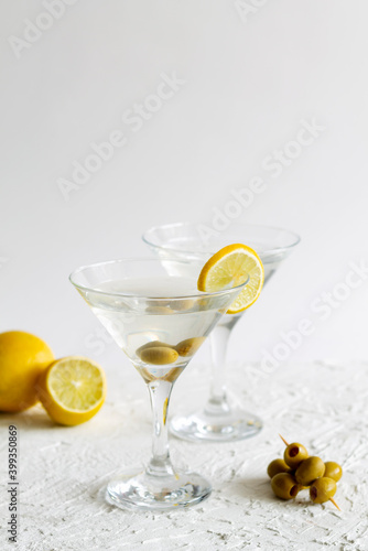 Two Martini glasses with cocktail and olives on white background. Cocktail Margarita with lime and lemon on the table. copy space. alcohol drinks. vertical.