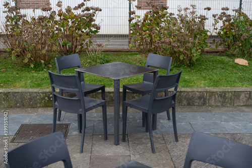 Mesas y sillas vacias en una terraza de un bar