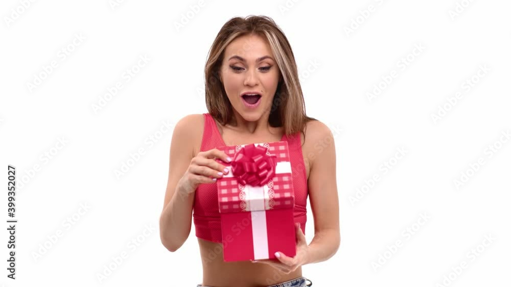 Portrait of amazed woman opening festive gift box rejoicing holiday isolated. 4k Dragon RED camera Portrait of amazed woman opening festive gift box rejoicing holiday isolated. 4k Dragon RED camera