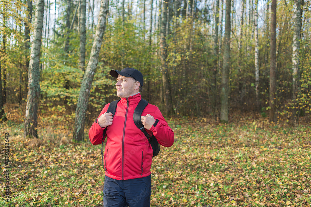 Young man with a backpack walks through the forest. Travel theme. Young man with a backpack walks through the forest Young man with a backpack walks through the forest. Travel theme. Young man with a backpack walks through the forest