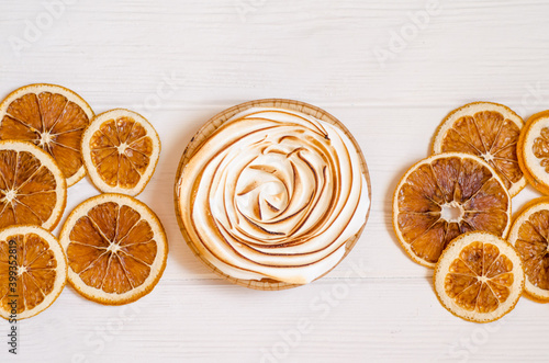 Delicious sweet orange tart with a baked top, white background with slices of dry fruit, as a background for holiday menus and posts