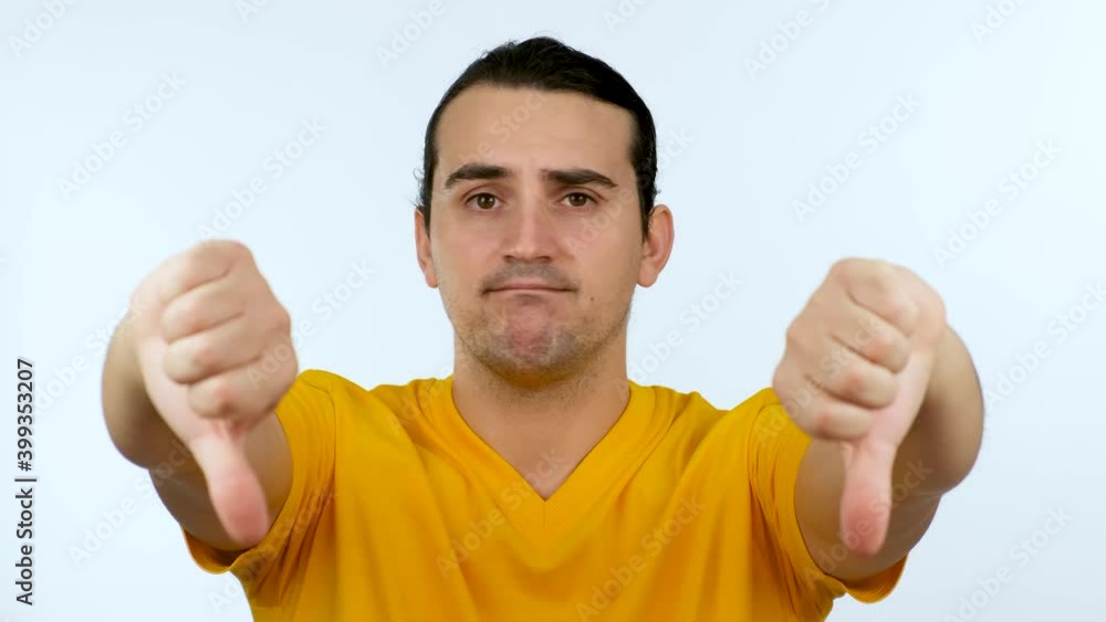 Man showing thumbs down, negative gesture and bad feedback, looking to camera isolated over white background. Man showing thumbs down, negative gesture and bad feedback, looking to camera isolated over white background.