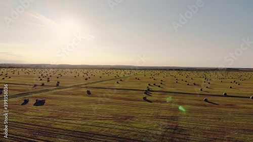 aerial shot beautiful sunset and hay bales on the field after harvest. Straw bales from a bird's eye view. The whole field is covered with bales of straw