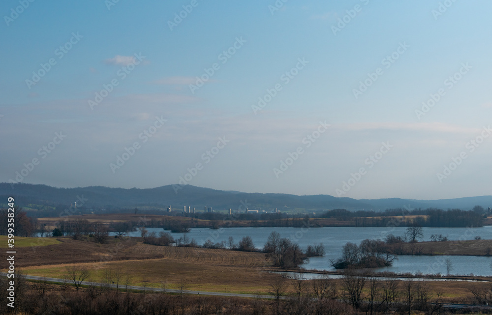 Landscape Of A Lake With Mountains And Farmland