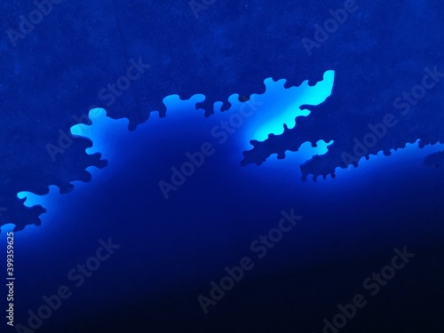 shades of bright neon blue and indigo colored symmetric intricate abstract patterns shapes and design on black background