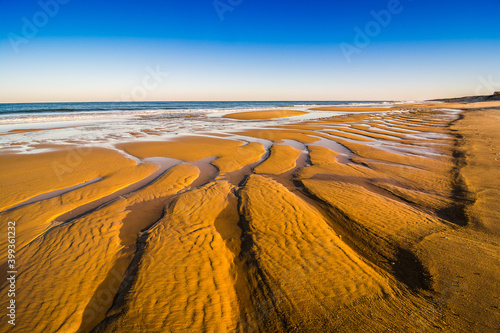 Orange sand beach in sunrise on the shore of North Atlantic Ocean in Mimizan Plage photo