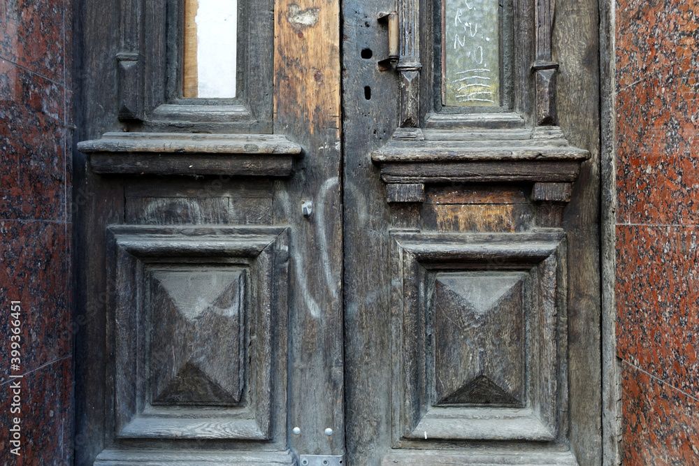 Wood texture of vintage entrance door to a house lined with granite