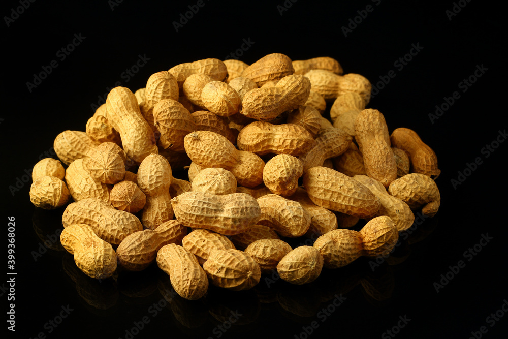 Peanuts in shell on a black background. Top view. Copy, empty space for text Peanuts in shell on a black background. Top view. Copy, empty space for text