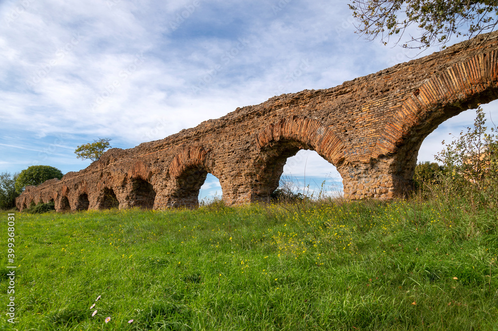 Alexandrian Aqueduct, the last of the great Roman aqueducts, built by the Emperor Alexander Severus. Detail of the arches and bricks on a sunny day and blue sky in the park, centocelle area. Rome.