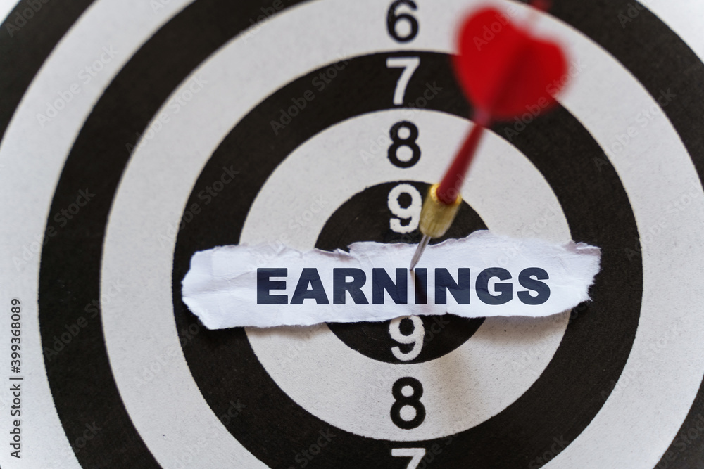 A piece of paper with the text is nailed to the target with a dart - EARNINGS A piece of paper with the text is nailed to the target with a dart - EARNINGS