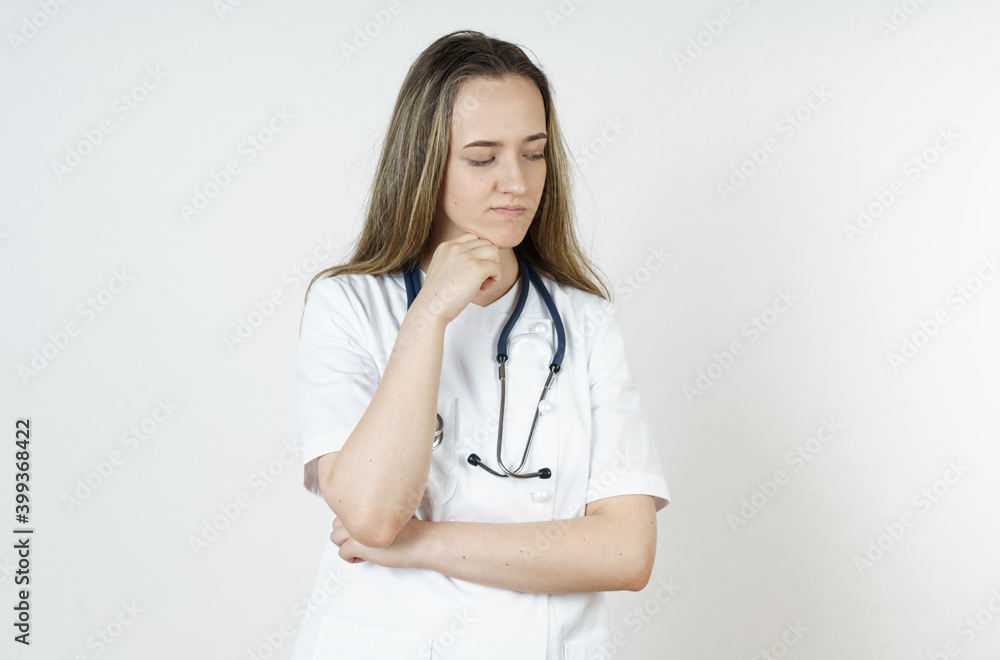 Medicine and health concept. A young woman doctor is thinking, dreaming. Medicine and health concept. A young woman doctor is thinking, dreaming.