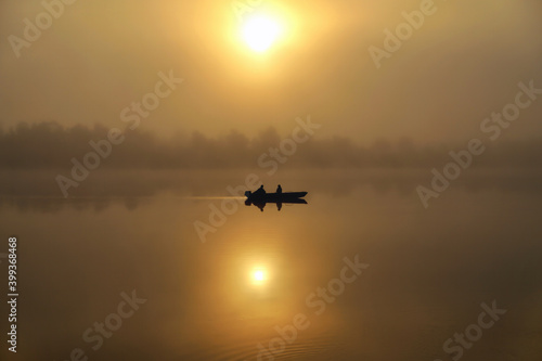 Morning. river, silhouette of a boat and fishermen, beautiful sunlight, reflection in the water of trees and the sun, a married couple in a boat, morning fishing, trolling