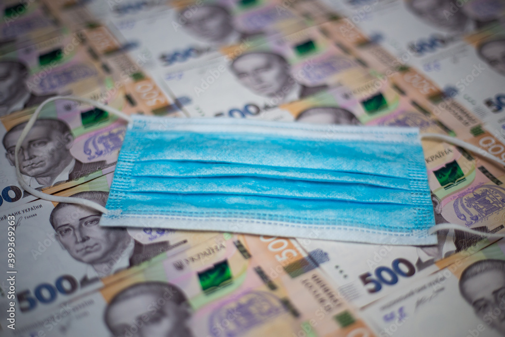 Kyiv, Ukraine 12.04.2020: Ukrainian national currency banknote hryvnia and protective medical mask. Cash of the National Bank of Ukraine. Kyiv, Ukraine 12.04.2020: Ukrainian national currency banknote hryvnia and protective medical mask. Cash of the National Bank of Ukraine.