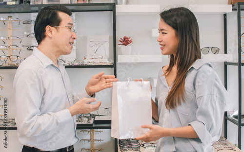 Asian female customer buying eyeglass at store