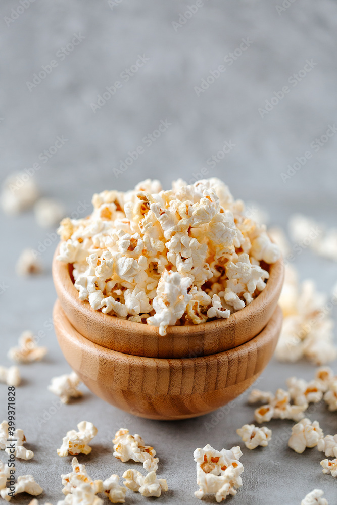 Popcorn in a wooden bowl on a grey background Popcorn in a wooden bowl on a grey background