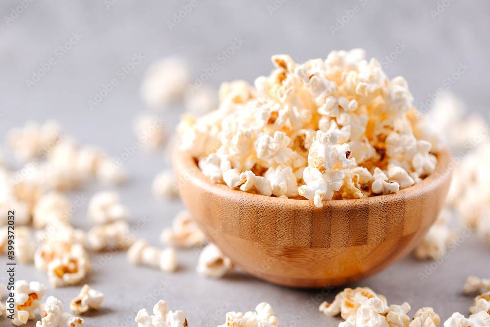 Homemade popcorn in a wooden bowl on a grey background Homemade popcorn in a wooden bowl on a grey background